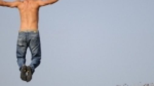 Man jumping at beach for short term health insurance
